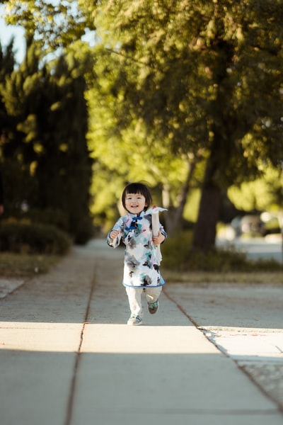 女孩走在灰色的水泥路上